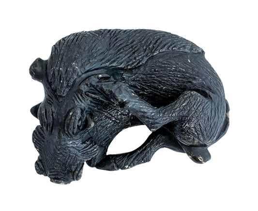 Folk art tribal African soapstone statue of a reclining warthog scratching its ear