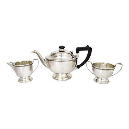 Three piece Art Deco sterling tea set with bow garlands and geometric handles