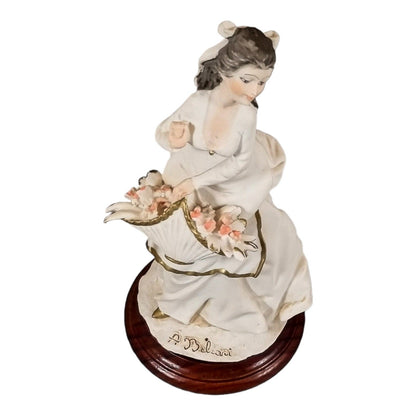 A. Belcari Capodimonte figurine of a young woman holding a flower basket