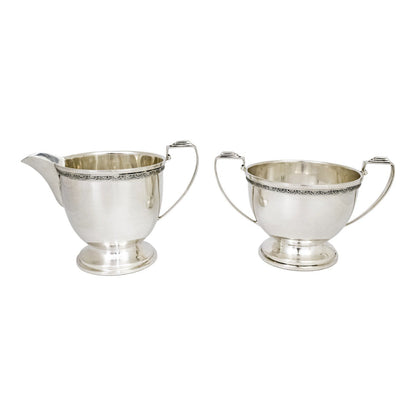 Three piece Art Deco sterling tea set with bow garlands and geometric handles