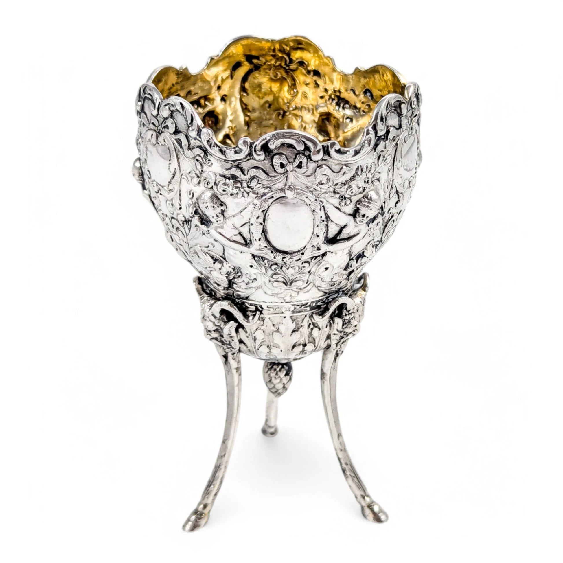 Hanau sterling silver tripod cup with repoussé putti, floral garlands, and ram’s head feet, Baroque Revival, c. 1880s