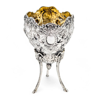 Hanau sterling silver tripod cup with repoussé putti, floral garlands, and ram’s head feet, Baroque Revival, c. 1880s