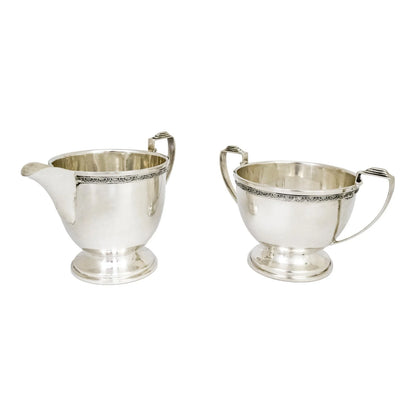 Three piece Art Deco sterling tea set with bow garlands and geometric handles