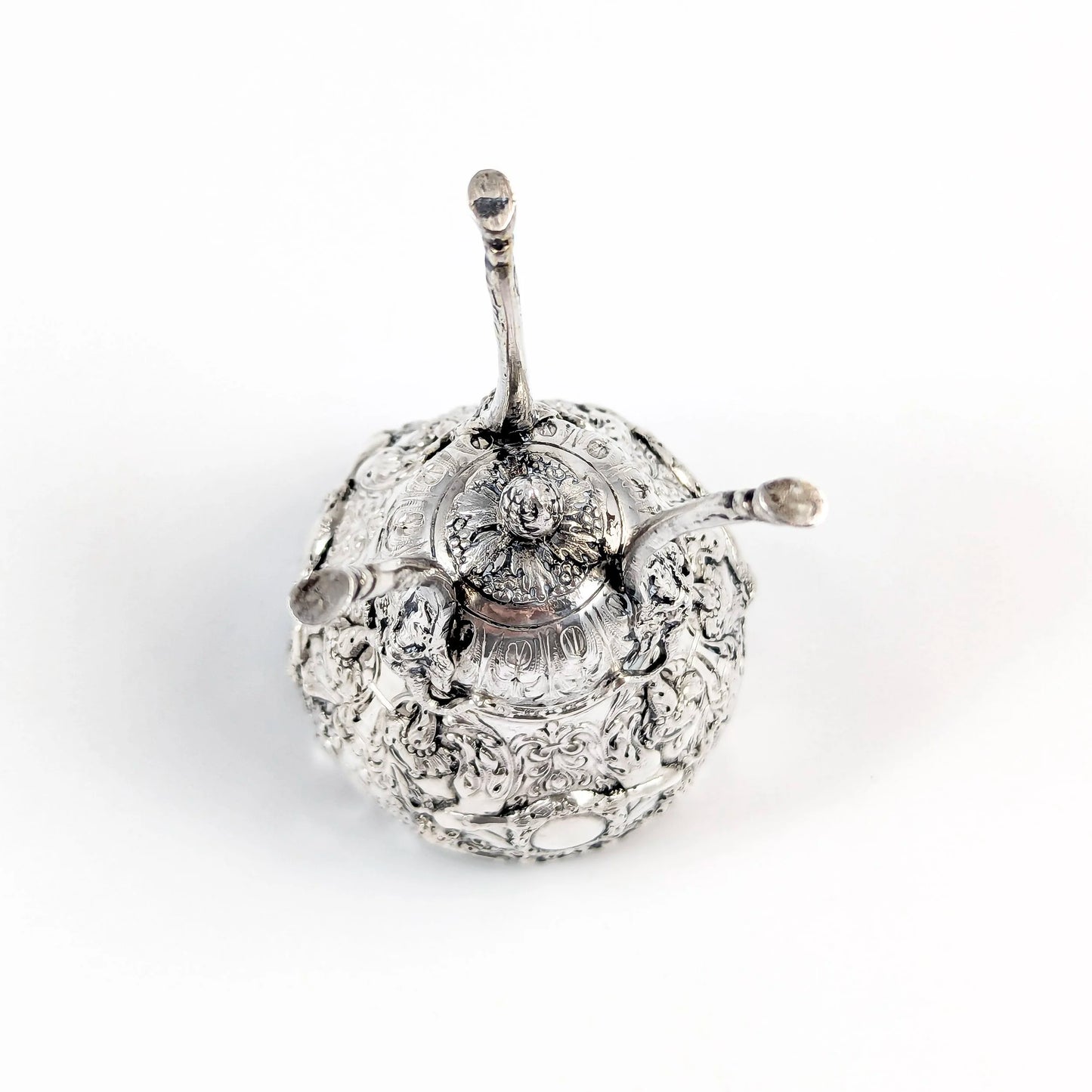 Hanau sterling silver tripod cup with repoussé putti, floral garlands, and ram’s head feet, Baroque Revival, c. 1880s