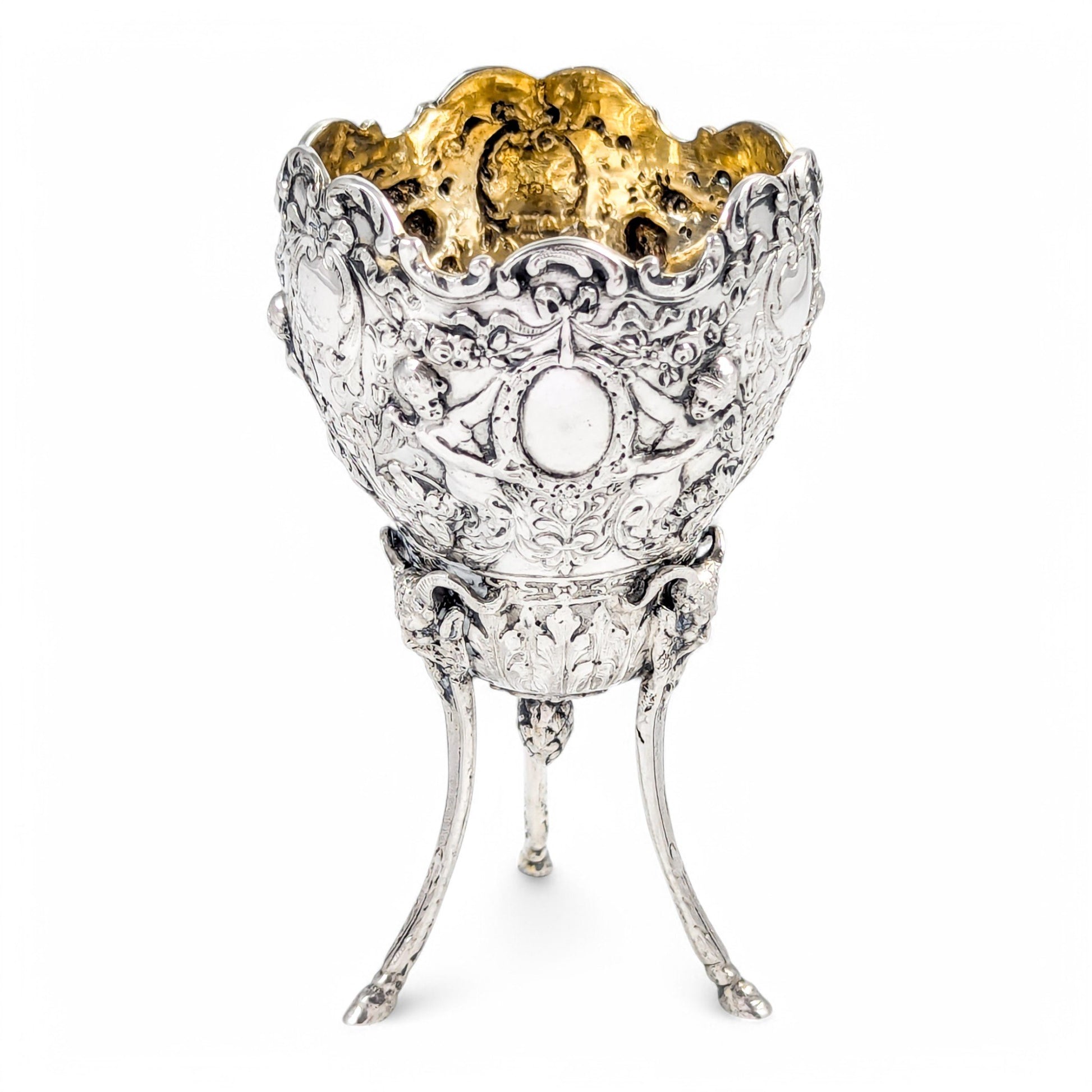 Hanau sterling silver tripod cup with repoussé putti, floral garlands, and ram’s head feet, Baroque Revival, c. 1880s
