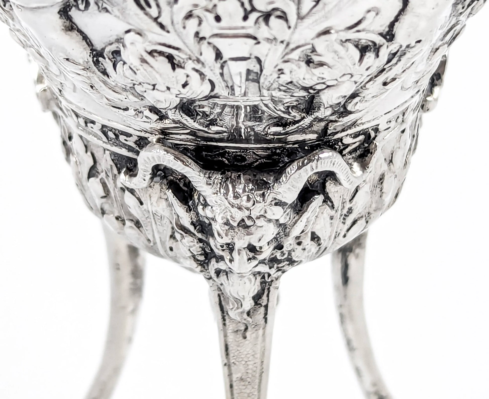 Hanau sterling silver tripod cup with repoussé putti, floral garlands, and ram’s head feet, Baroque Revival, c. 1880s