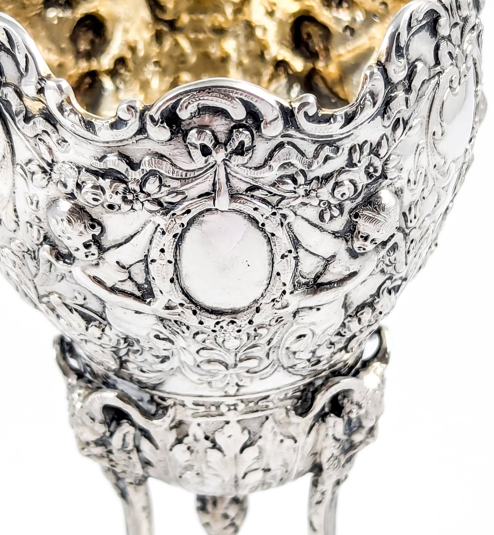 Hanau sterling silver tripod cup with repoussé putti, floral garlands, and ram’s head feet, Baroque Revival, c. 1880s