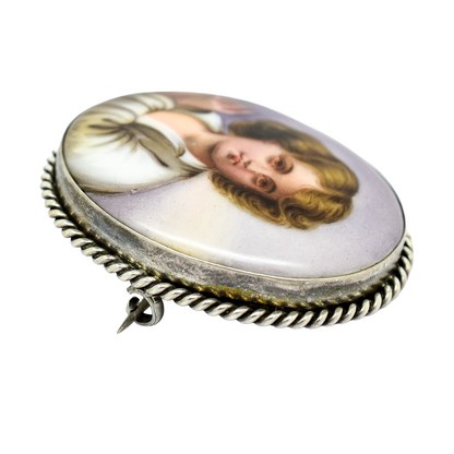 Victorian hand-painted porcelain portrait of a boy brooch in twisted rope silver frame