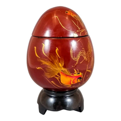 Egg-shaped large red lacquerware box on stand, gilded and painted with angelfish
