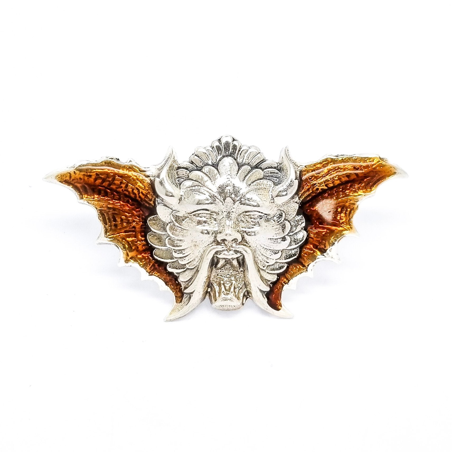 Quirky winged devil face brooch in sterling silver and orange enamel