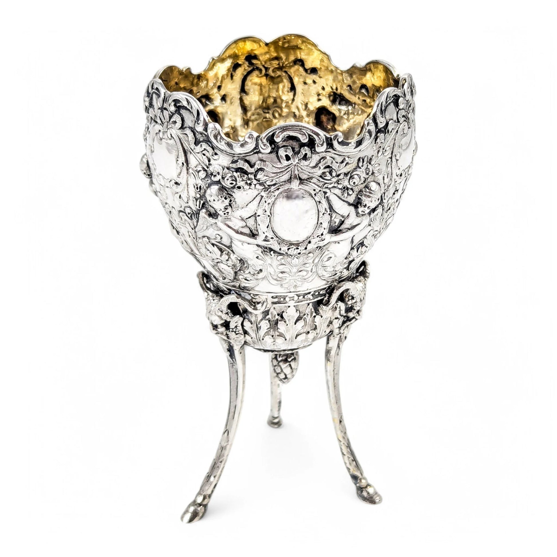 Hanau sterling silver tripod cup with repoussé putti, floral garlands, and ram’s head feet, Baroque Revival, c. 1880s