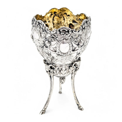Hanau sterling silver tripod cup with repoussé putti, floral garlands, and ram’s head feet, Baroque Revival, c. 1880s