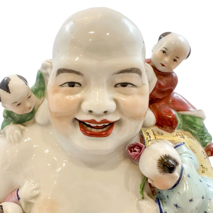 Vintage Chinese porcelain laughing Buddha figurine with children, a symbol of fertility
