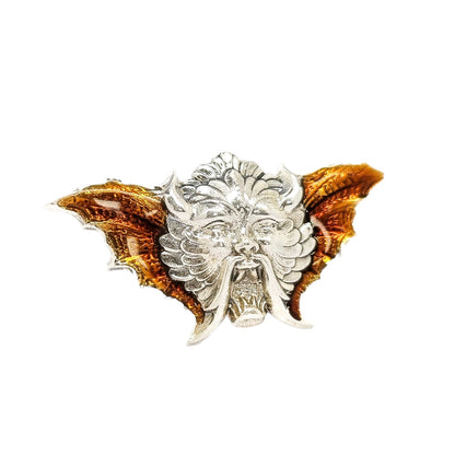 Quirky winged devil face brooch in sterling silver and orange enamel