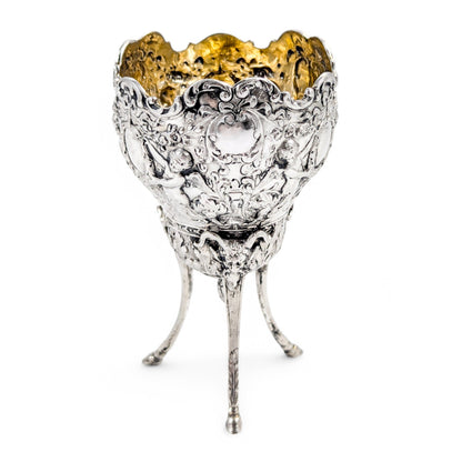 Hanau sterling silver tripod cup with repoussé putti, floral garlands, and ram’s head feet, Baroque Revival, c. 1880s