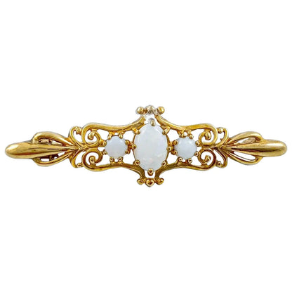 Art Nouveau style yellow gold brooch set with cabochon opals in a scrolling design