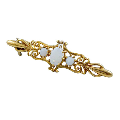 Art Nouveau style yellow gold brooch set with cabochon opals in a scrolling design