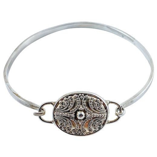 Suarti Bali sterling silver bangle bracelet with an oval medallion decorated with beaded scrolls