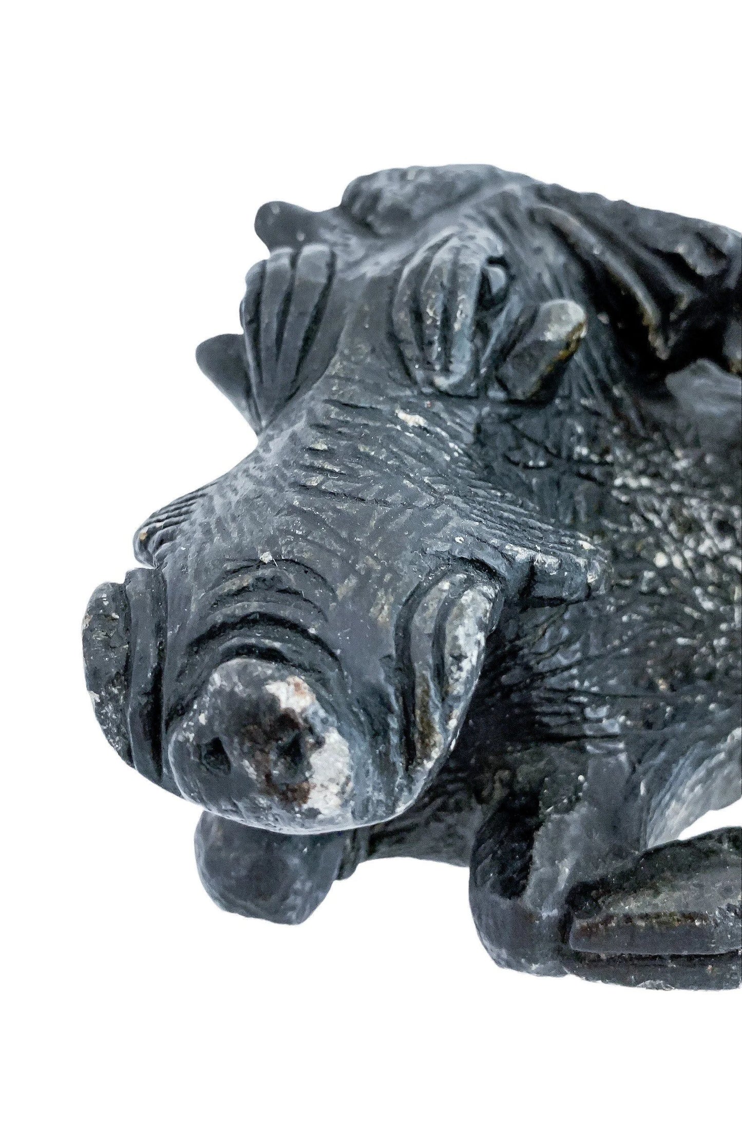 Folk art tribal African soapstone statue of a reclining warthog scratching its ear
