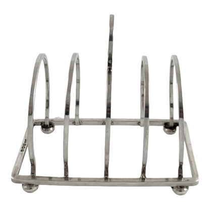 George V round sterling silver 4 slot 5 bar toast rack raised on bun feet, Walker & Hall