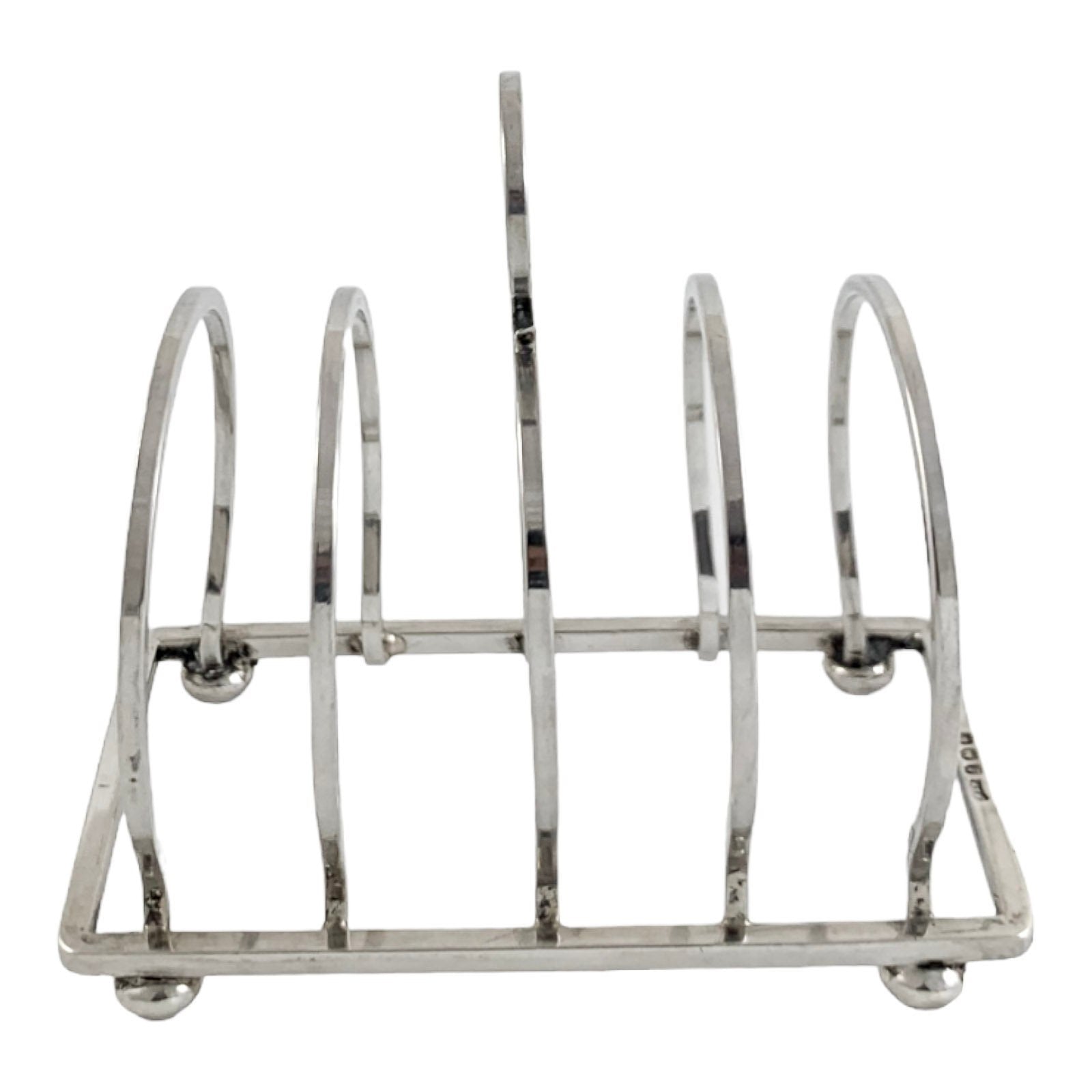 George V round sterling silver 4 slot 5 bar toast rack raised on bun feet, Walker & Hall