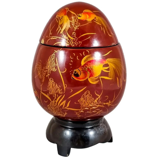 Egg-shaped large red lacquerware box on stand, gilded and painted with angelfish