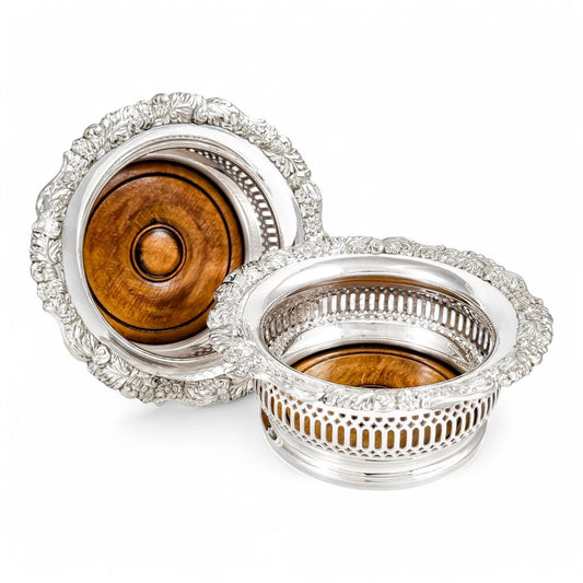 Antique silver plated magnum bottle coasters with Rococo foliate borders and mahogany bases, c. 1880s